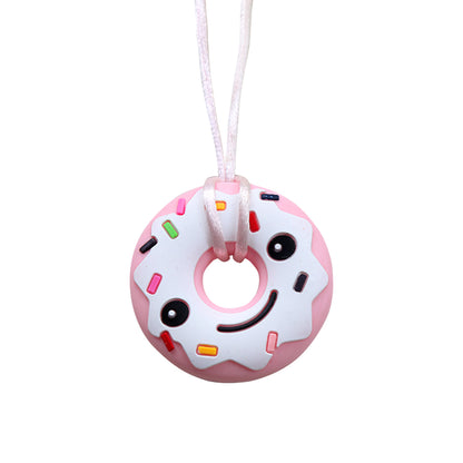 Pink donut silicone pendant on pink cord chewable necklace for sensory needs with smiling frosting and sprinkles