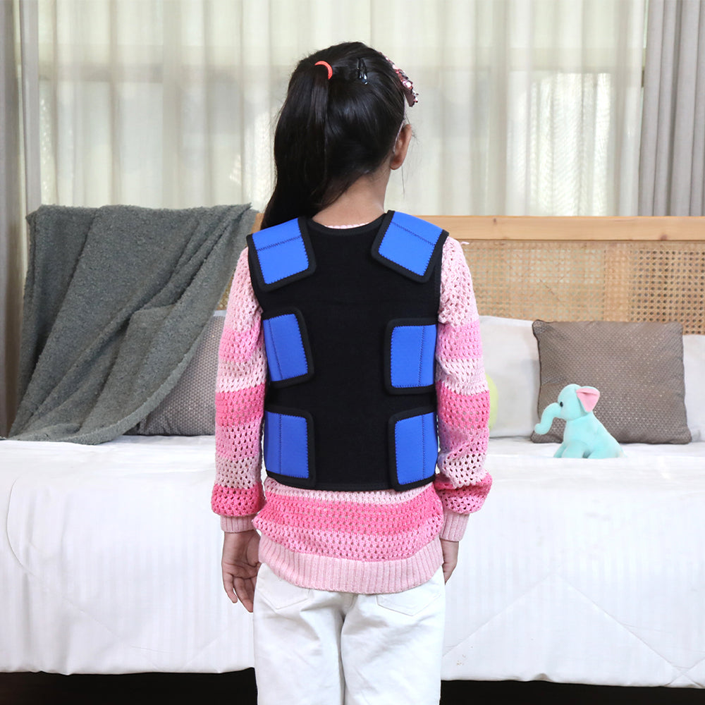 Ableys compression vest for sensory needs on child with blue back pads worn over pink sweater in bedroom
