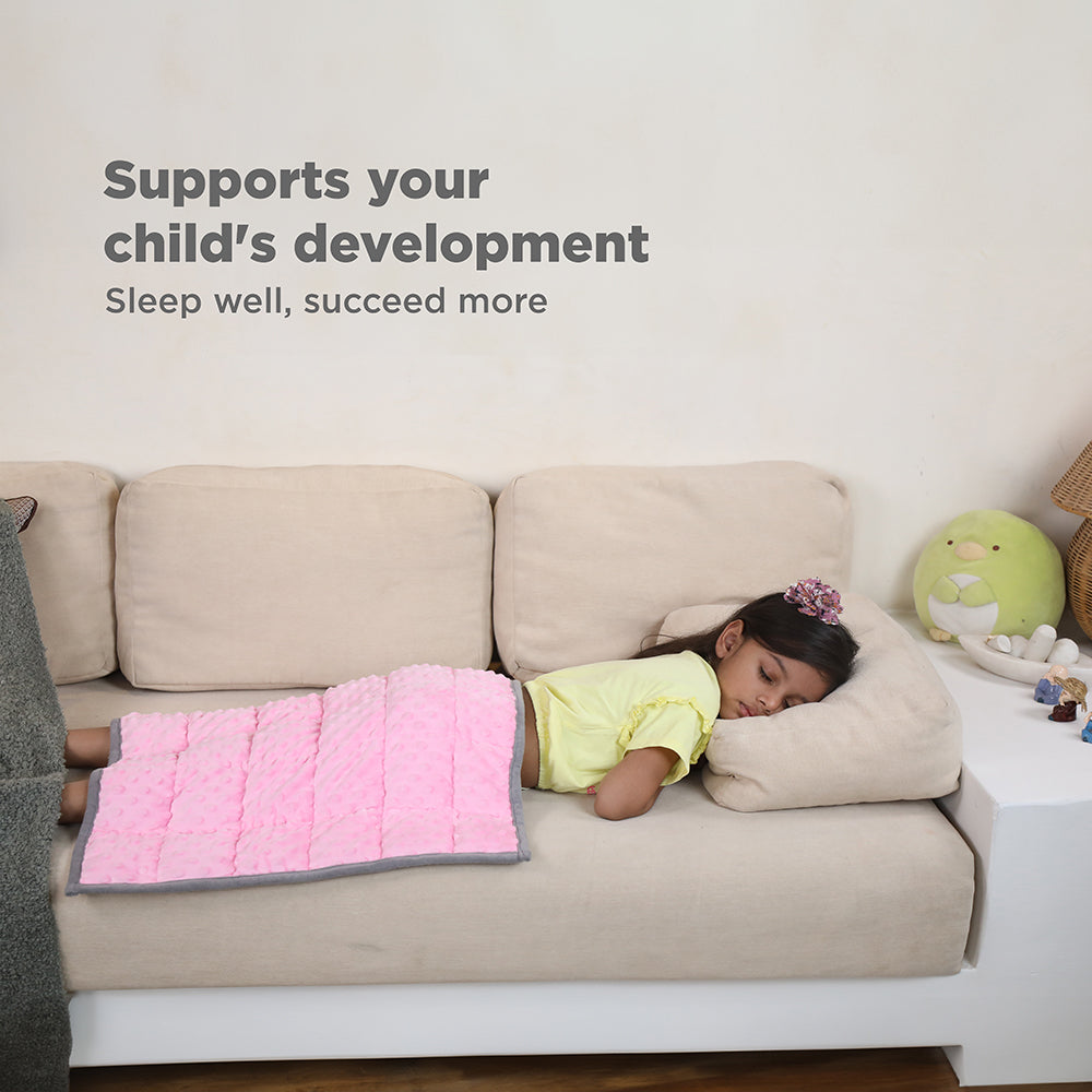Ableys pink weighted lap pad for focus on a child sleeping on a beige couch with pillow