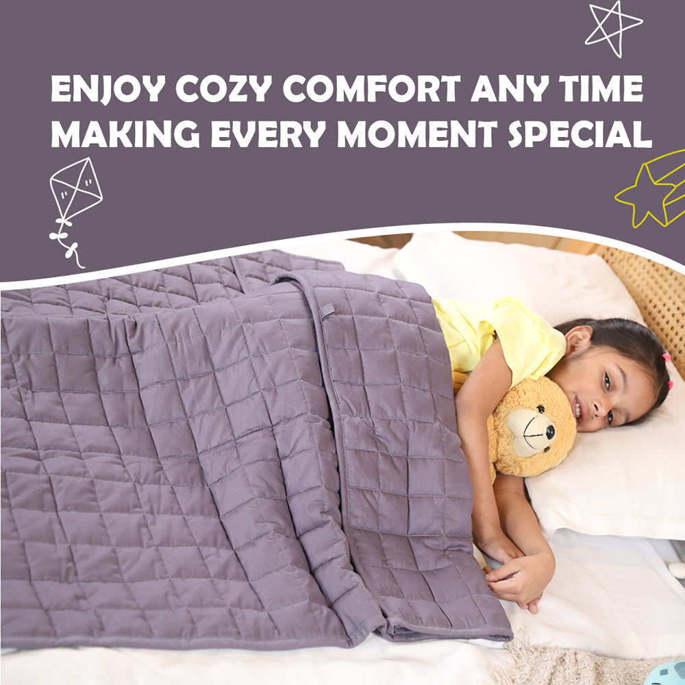 Ableys weighted blanket for kids gray quilted comforter covering a smiling child holding a teddy bear