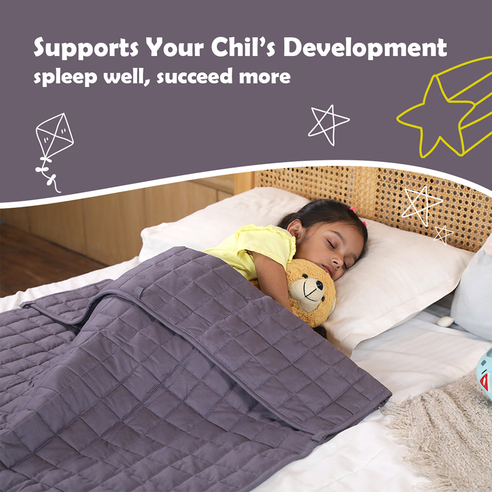 Young girl sleeping on bed hugging teddy under gray quilted weighted blanket for kids by Ableys