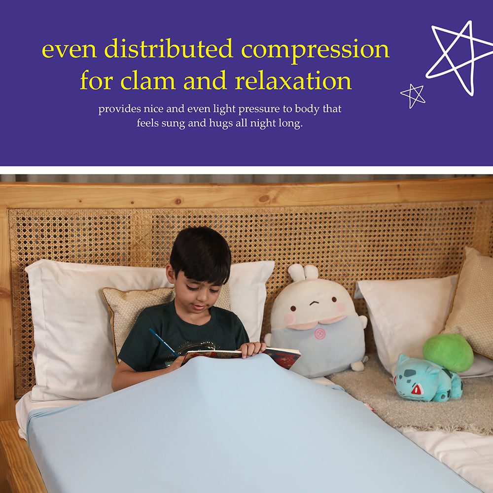 Ableys compression bed sheet for sensory needs on child reading in bed with light blue fitted sheet and plush toys