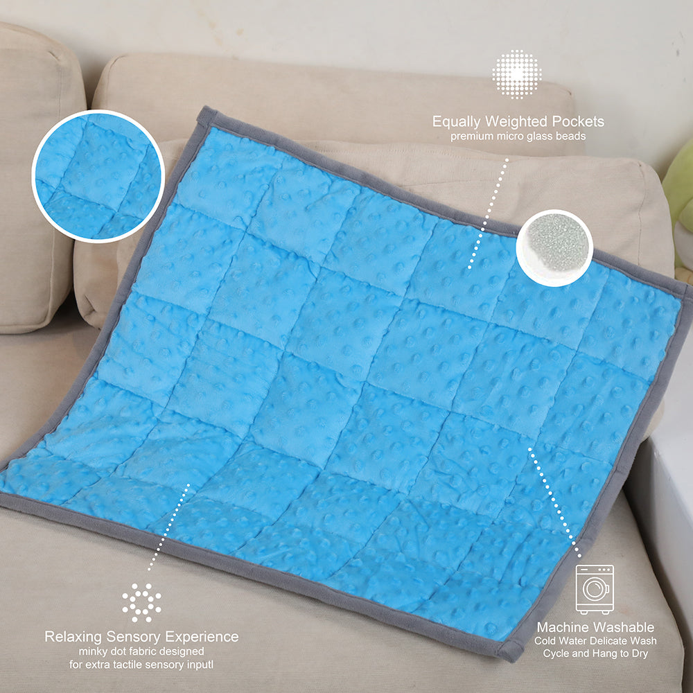 Ableys blue quilted weighted lap pad for focus on couch with gray trim and textured pockets