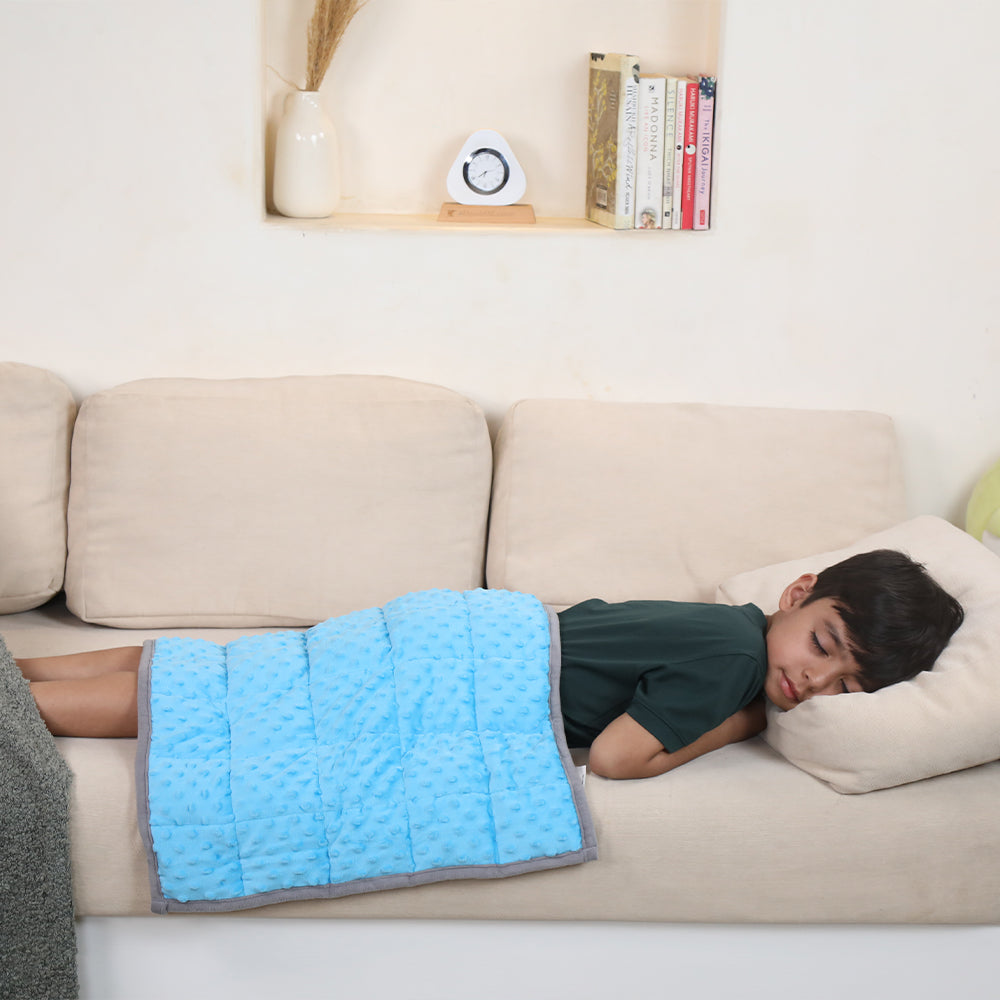 Ableys weighted lap pad for focus blue textured lap pad on child napping on beige couch